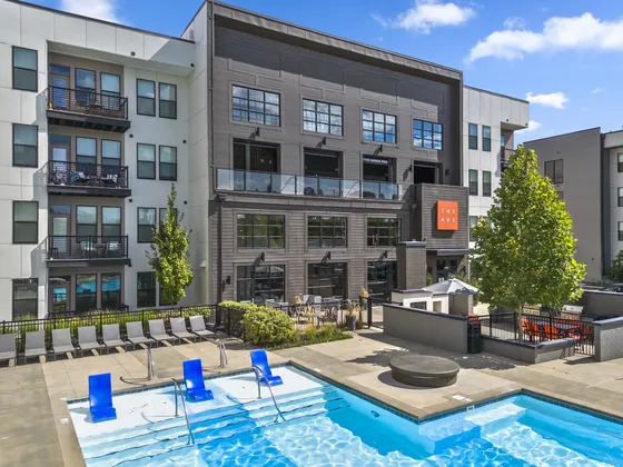 Modern apartment complex with a luxurious outdoor pool and stylish balcony views, perfect for relaxation and entertainment.
