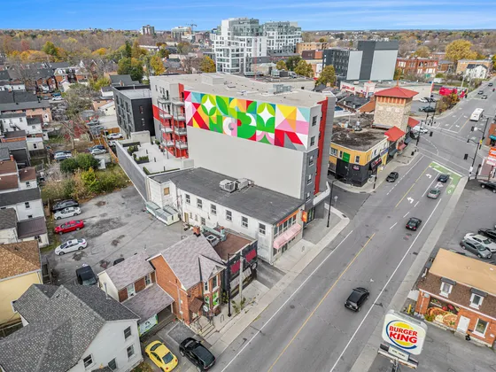 Vibrant urban scene with colorful mural-adorned apartment building, showcasing modern living in a bustling neighborhood.
