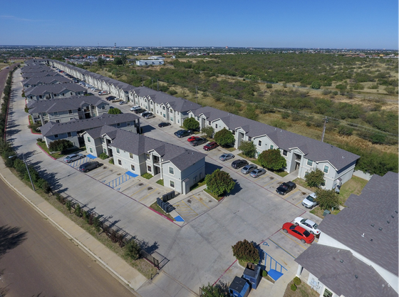 Charming suburban apartment complex with modern two-story units, ample parking, and lush greenery, perfect for comfortable living and community engagement.