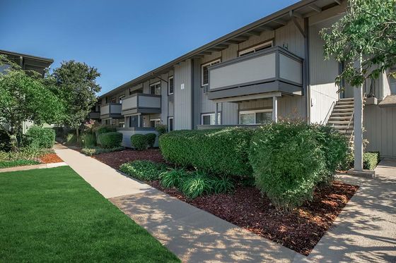 Creekside Apartments Building Exterior with Balconies and Lush Landscaping