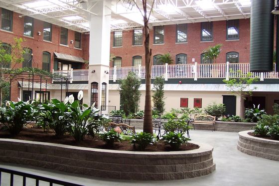 Charming indoor courtyard with lush greenery, elegant seating areas, and exposed brick walls, perfect for relaxation and social gatherings.