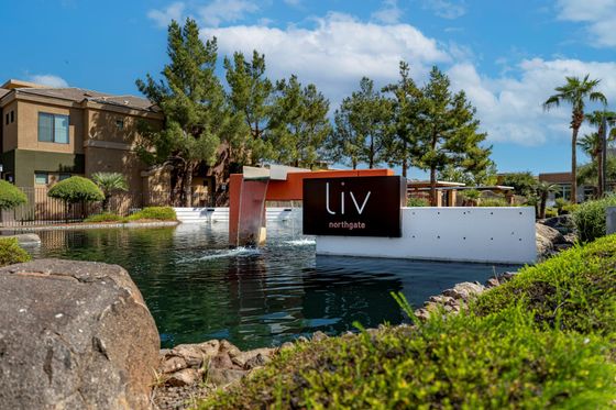 Modern apartment complex with scenic water feature and lush greenery at Liv Northgate.