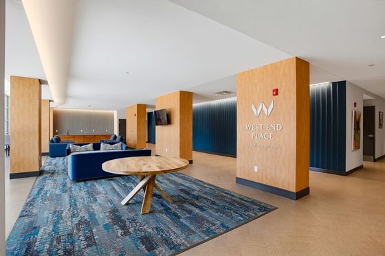 Modern communal space at West End Place, Lancaster, featuring elegant wood accents, plush blue seating, and contemporary decor.