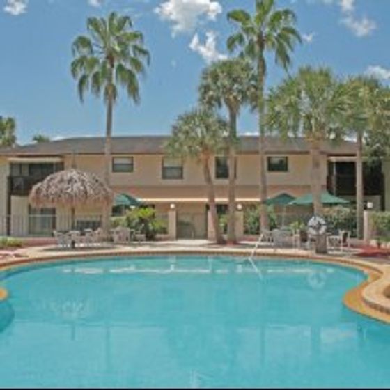 Marcell Gardens Apartments, exterior, sparkling blue swimming pool, two story building, palm trees