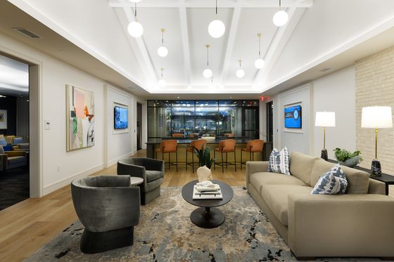 Contemporary open-concept living room with elegant furnishings, stylish lighting, and a chic bar area perfect for entertaining.