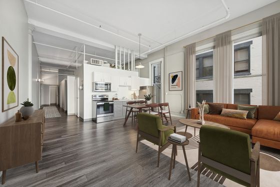 Bright and spacious open-concept living room with modern kitchen and stylish decor.