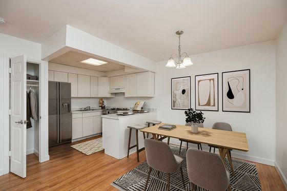 Inviting open-concept kitchen and dining area with sleek cabinetry, modern appliances, and elegant artwork.