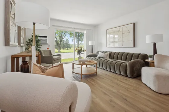 Bright and inviting living room with modern furnishings, elegant couch, large windows offering scenic views, and stylish decor.
