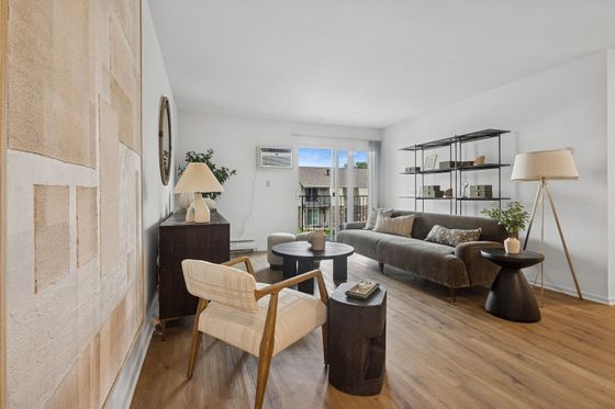 Chic living room with modern furniture, sleek hardwood floors, and large windows offering a bright, airy ambiance.