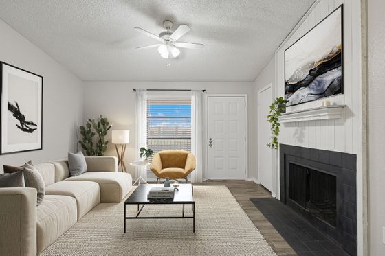 Chic living room boasting a cozy beige sectional, vibrant artwork, and a modern fireplace, perfect for relaxation.