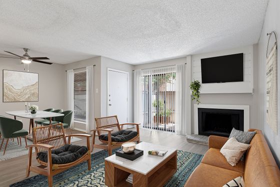 Elegant living room with modern decor, featuring a cozy fireplace, stylish seating, and natural light from large sliding glass doors.