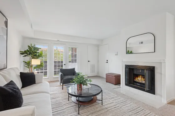 Bright living room with modern decor, featuring a cozy fireplace, plush sofa, and elegant furnishings, perfect for relaxation.