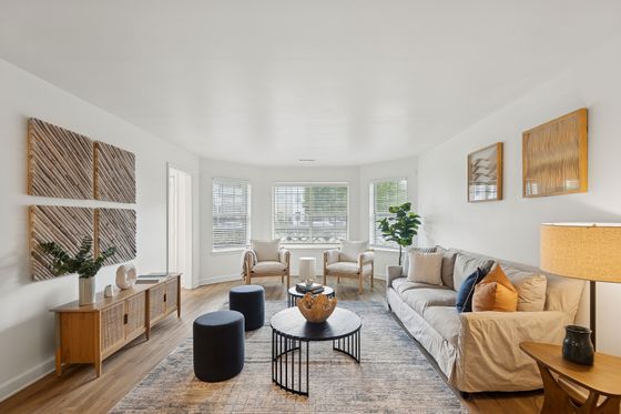 Elegant living room with cozy furniture, stylish decor, and large windows allowing natural light to illuminate the inviting space.