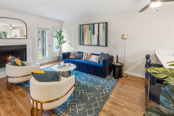 Chic living room with a cozy fireplace, plush blue sofa, and elegant decor creating a warm and inviting atmosphere.