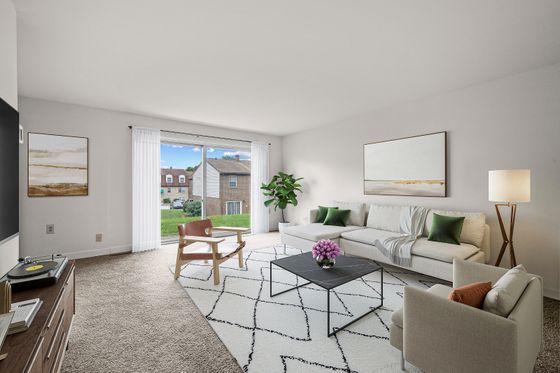 Bright and inviting living room with large windows, modern furniture, and tasteful decor, offering a comfortable and stylish space for relaxation.