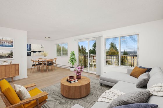 Bright and airy living room featuring modern decor, floor-to-ceiling windows with scenic views, and a cozy dining area.