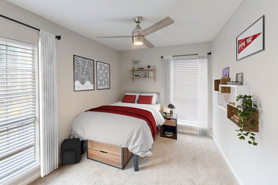 Bright and cozy bedroom featuring elegant modern decor, a plush bed with red accents, large windows allowing natural light, and stylish shelving with decorative items.