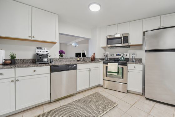 Modern kitchen with stainless steel appliances, sleek cabinetry, and granite countertops, creating an inviting culinary space.