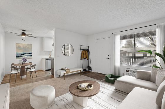 Modern living room with stylish decor, cozy sectional sofa, and abundant natural light near a compact dining area.