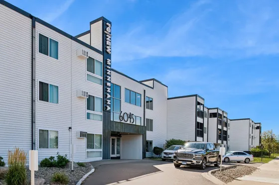 Modern apartment complex with sleek design and ample parking, offering comfortable urban living.