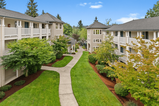 Charming apartment courtyard with lush landscaping, meandering pathways, and cozy balconies, ideal for relaxed living.