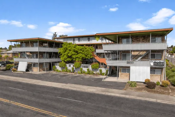 Modern three-story apartment complex with spacious balconies and lush landscaping, offering prime now renting opportunities.