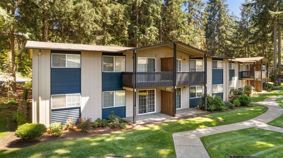 Charming apartment complex nestled in lush greenery with scenic pathways and a two-story design.