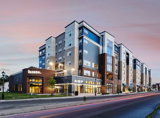 Modern urban apartment complex with stylish architecture and vibrant evening atmosphere.