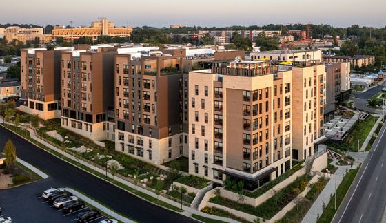 Modern apartment complex with sleek architecture, lush landscaping, and scenic views, located in vibrant Bloomington neighborhood.