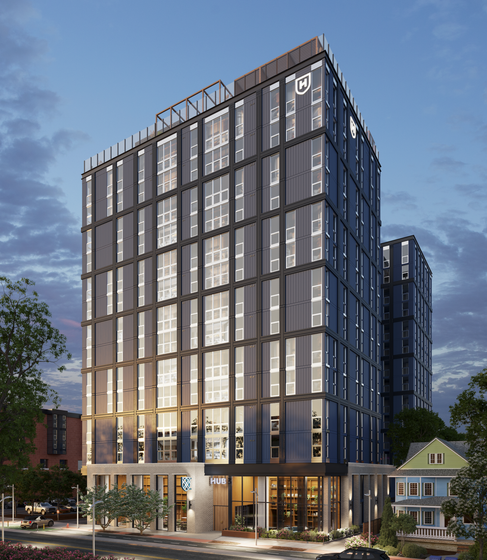 Modern high-rise apartment building with sleek architecture, featuring extensive glass windows and contemporary design, set against a vibrant twilight sky.
