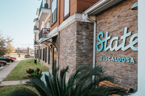 Charming modern apartment exterior with stylish stone facade and inviting balconies at State Tuscaloosa.
