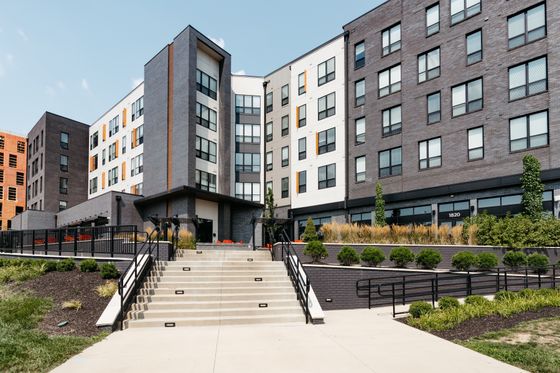 Modern apartment building with sleek architecture, featuring well-maintained landscaping and inviting entrance sets a welcoming tone.