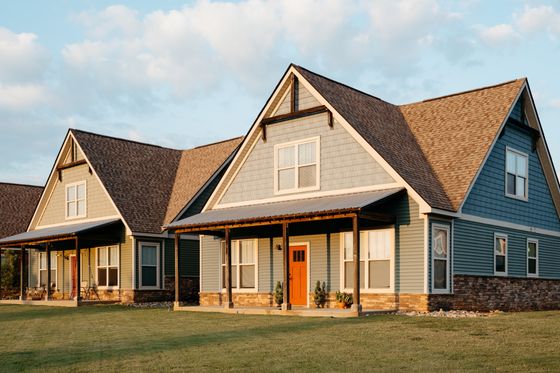 Charming suburban homes with inviting porches and vibrant exteriors, bathed in golden sunlight.