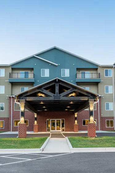 Crescent Falls apartment exterior with welcoming entrance and landscaping at sunset
