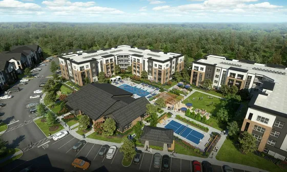 Aerial view of a luxurious apartment complex featuring modern buildings, a large swimming pool, landscaped gardens, a tennis court, and ample parking, surrounded by lush greenery.
