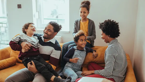 man and woman with three kids on couch in living area