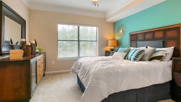Furnished bedroom with teal accent wall