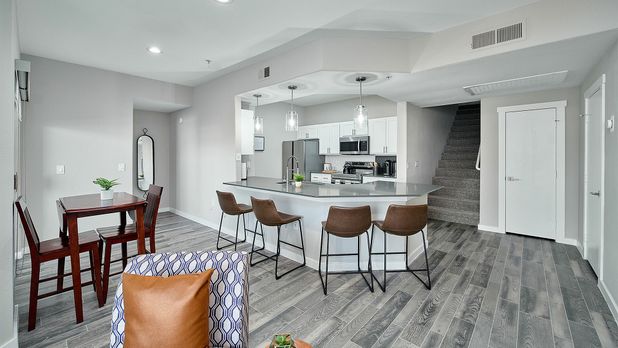 Stylish open-plan kitchen with breakfast bar seating, modern appliances, and cozy dining area.