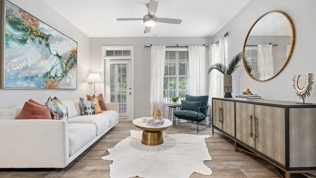 Living room with couch, coffee table and door to attached balcony/patio