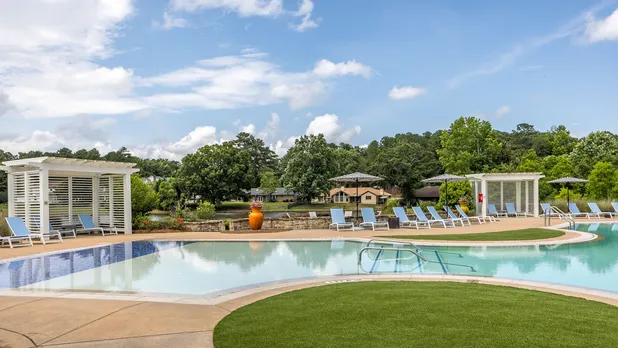 pool with lounge chairs and view of lake