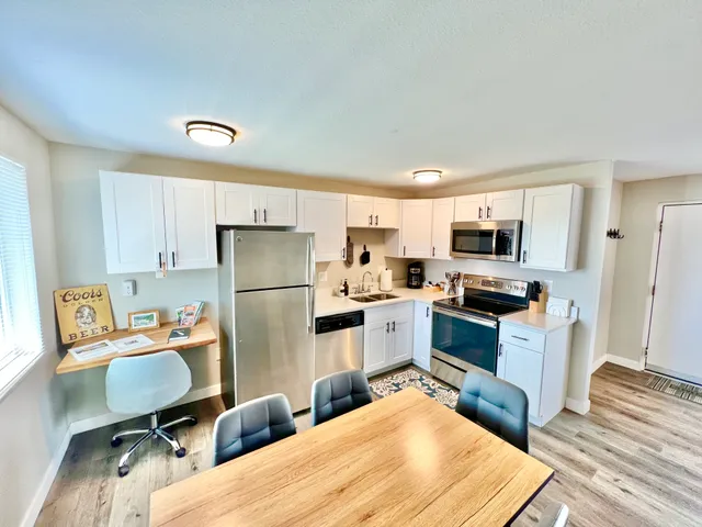 Bright modern kitchen with stainless steel appliances and white cabinetry.