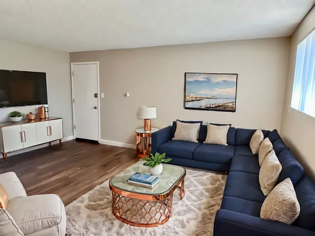 Inviting living room with a chic navy sofa, elegant copper accents, and cozy decor, creating a warm and stylish ambiance.