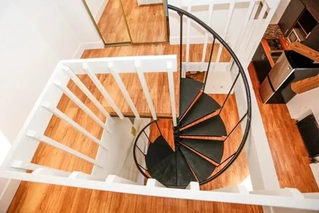 Elegant spiral staircase with sleek black steps, enhancing the modern interior charm.