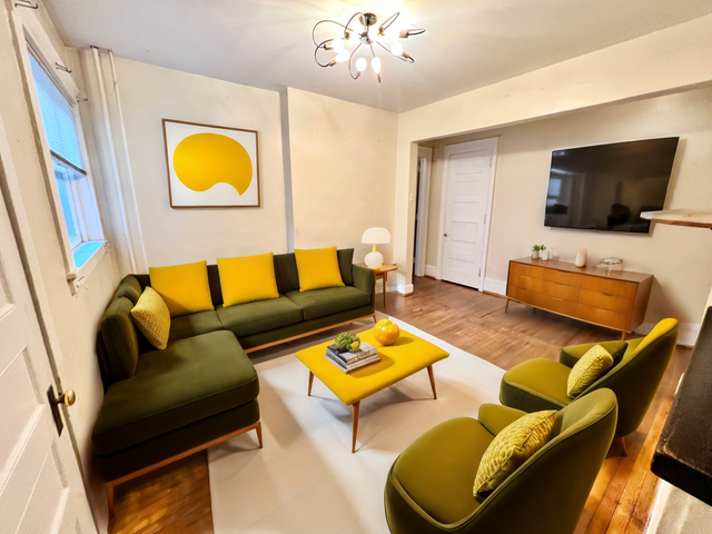 Bright and modern living room featuring a stylish green and yellow color scheme, elegant artwork, and sleek lighting.