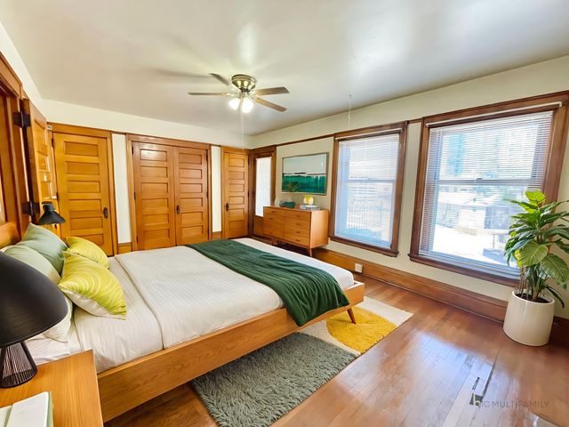 Inviting bedroom with warm wood accents, large windows, and modern decor for a cozy retreat.