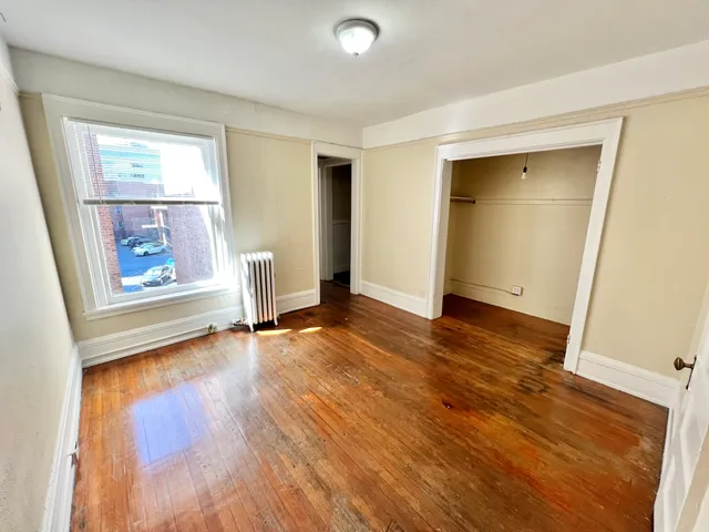 Bright and inviting room with large window, hardwood floors, and spacious closet, perfect for a cozy retreat.