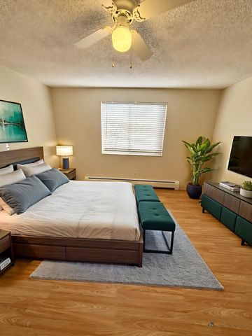 Inviting bedroom with a modern design, featuring a spacious bed, stylish furniture, and warm natural lighting.