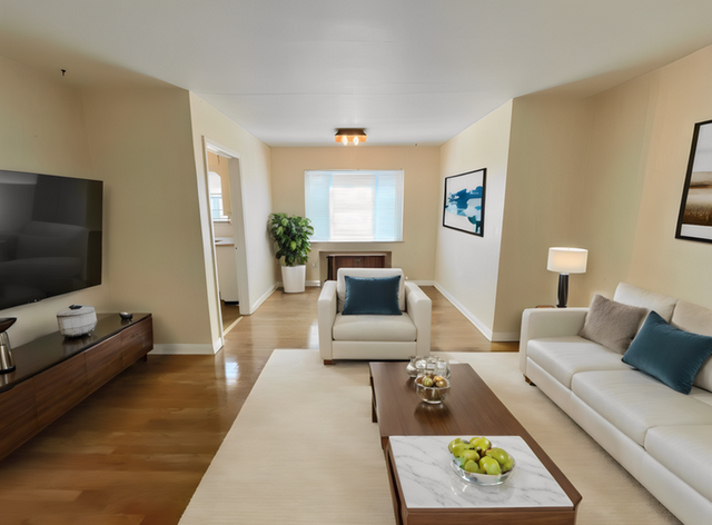 Elegant living room with modern decor, featuring cozy white sofas, a sleek wooden coffee table, and a large flat-screen TV for a luxurious atmosphere.