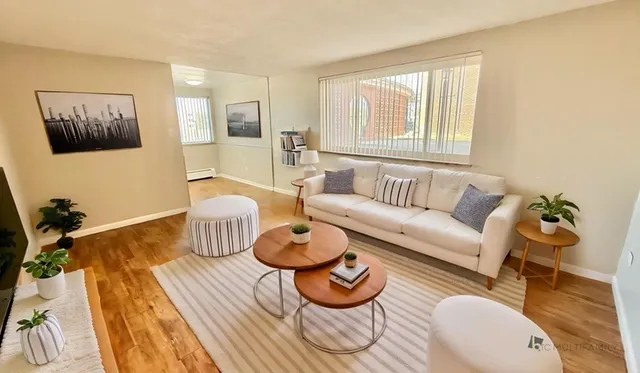 Inviting living room with natural light, featuring a plush sofa, chic tables, and elegant decor.