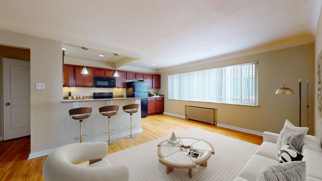 Modern open-concept living area with elegant kitchen, featuring bar seating and stylish d&eacute;cor, perfect for entertaining.
